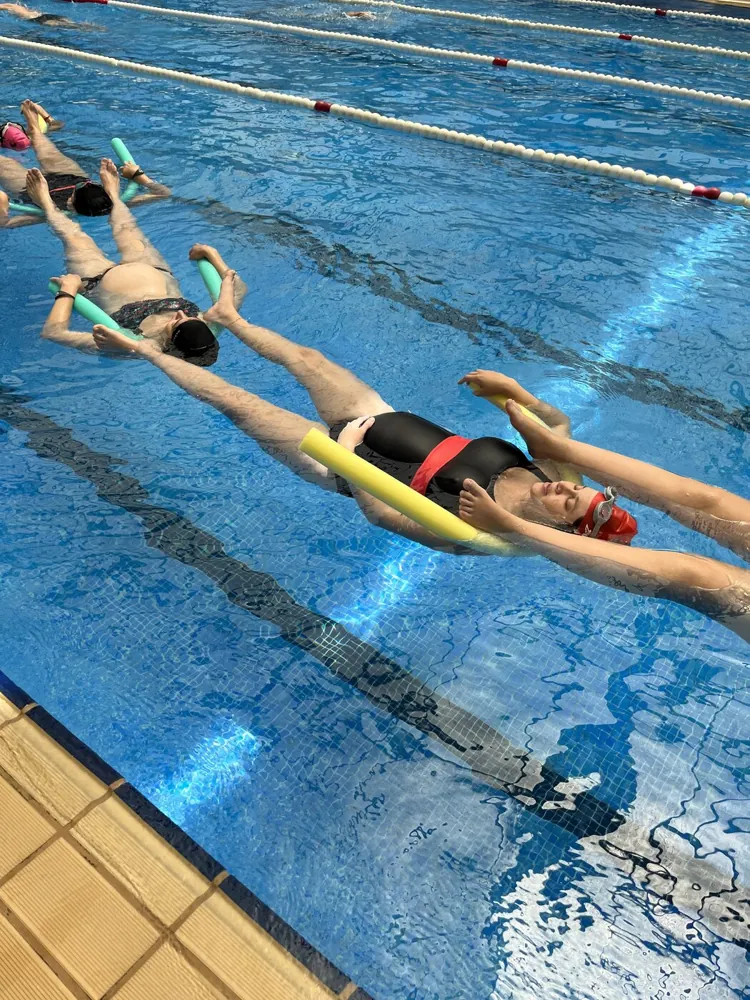 Embarazadas flotando con churros en una clase de matronatación