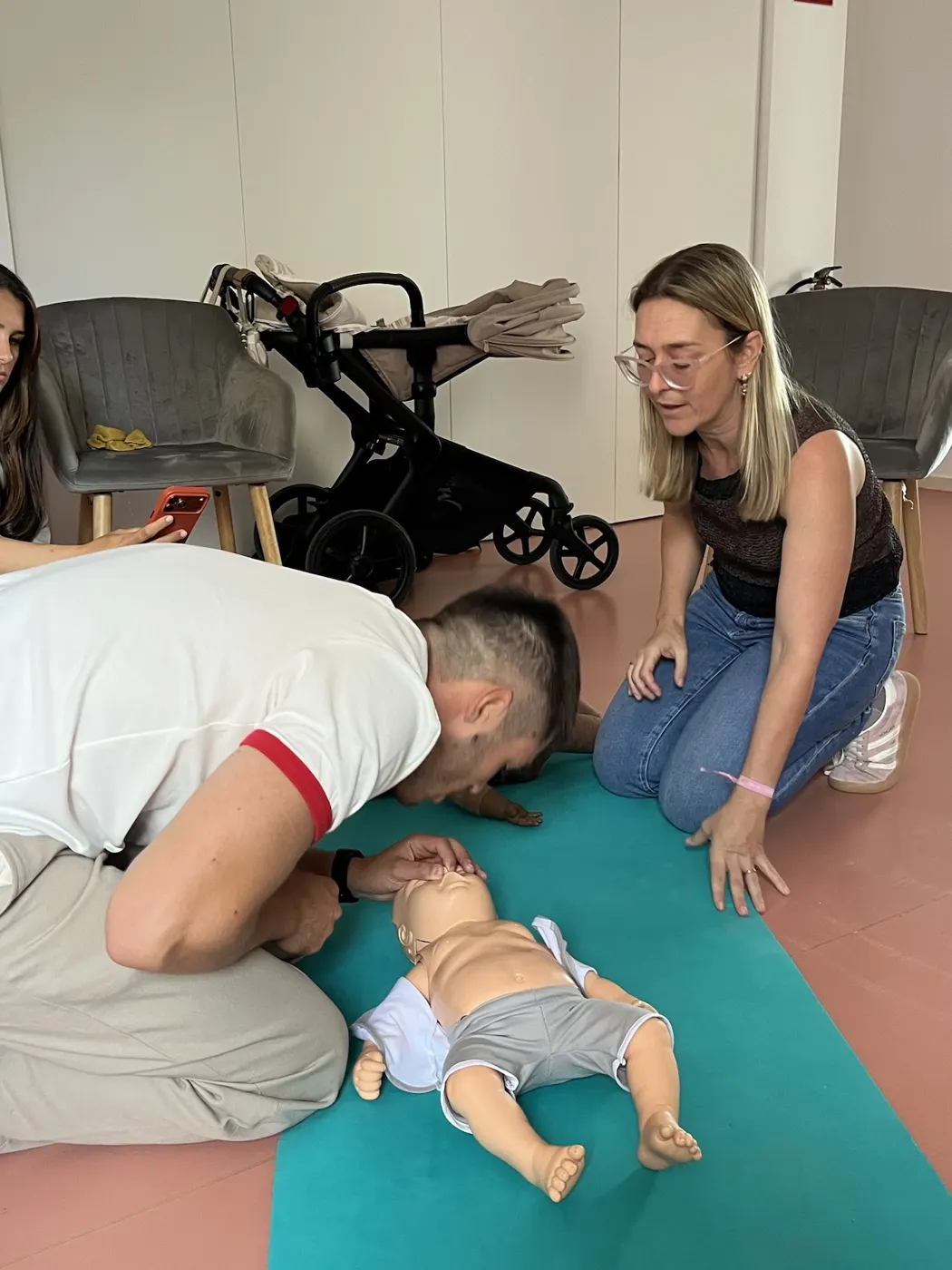 Padre practicando RCP pediátrica con un maniquí en el taller de Mimando a Mamá en Alicante